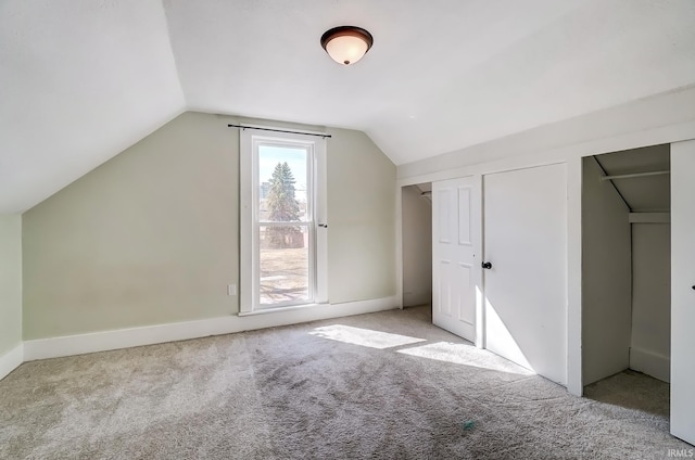 additional living space featuring vaulted ceiling and carpet floors