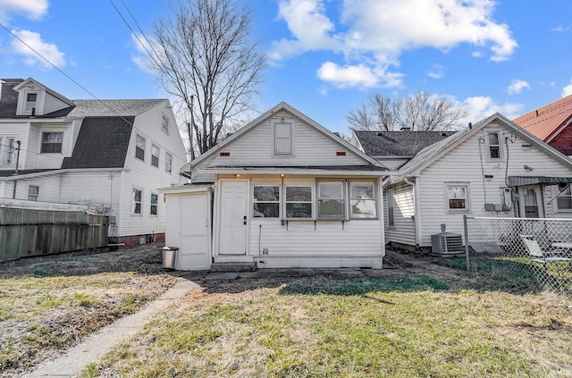 back of property featuring cooling unit, fence, and a lawn