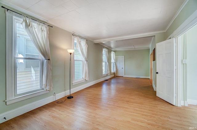 unfurnished room with crown molding, light wood-style floors, and baseboards