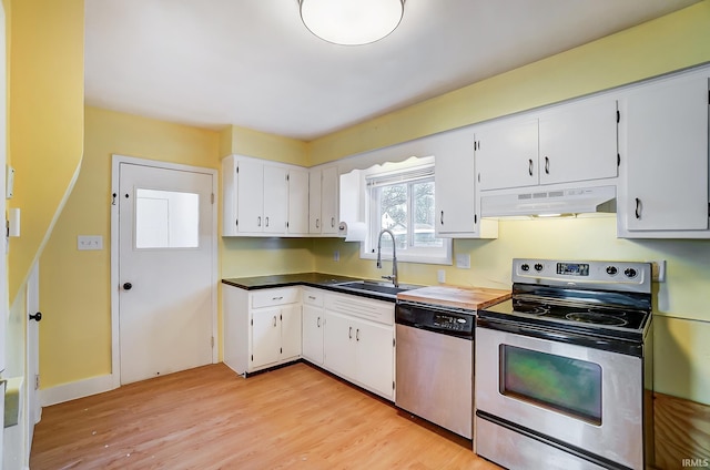 kitchen featuring a sink, stainless steel appliances, white cabinets, light wood-style floors, and under cabinet range hood