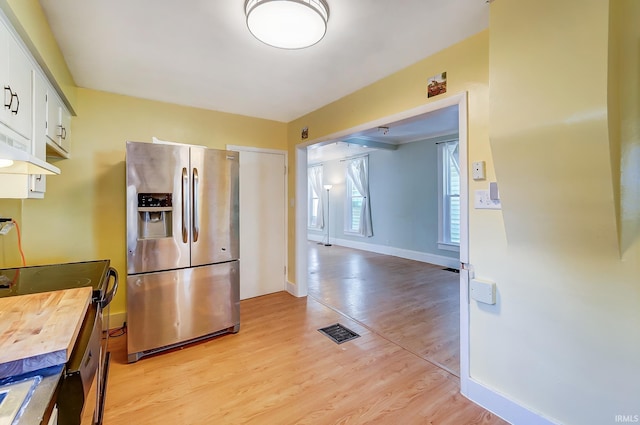 kitchen featuring baseboards, visible vents, light wood-style flooring, appliances with stainless steel finishes, and white cabinetry