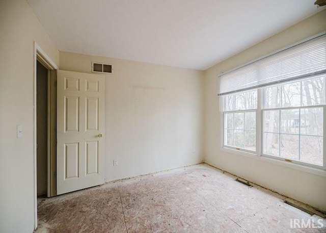 unfurnished room featuring visible vents