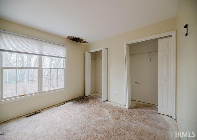 unfurnished bedroom with two closets