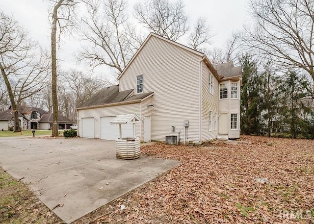 view of home's exterior with central air condition unit and driveway