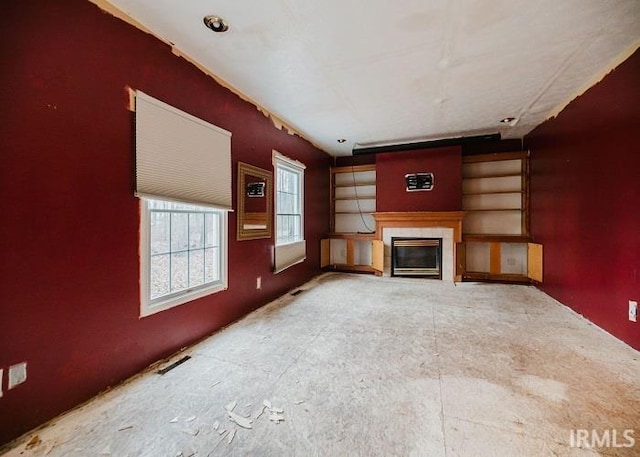 unfurnished living room featuring a glass covered fireplace and visible vents