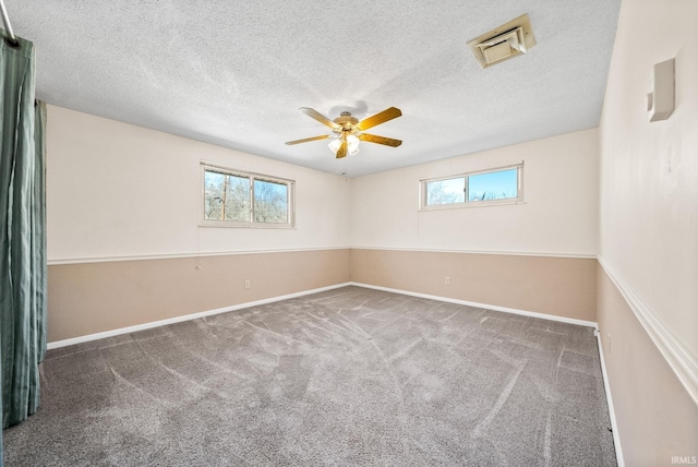 empty room featuring plenty of natural light, baseboards, ceiling fan, and carpet floors