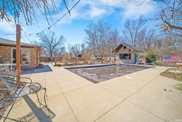 view of swimming pool featuring an exterior structure, a fenced in pool, a patio, and an outdoor structure