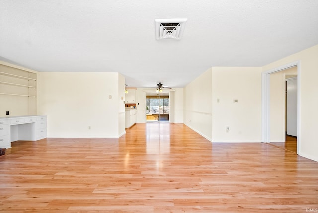 unfurnished living room with light wood-type flooring, visible vents, a textured ceiling, and ceiling fan