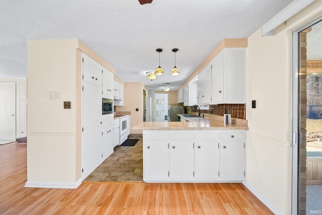 kitchen with white electric range oven, light wood-style flooring, a sink, light countertops, and white cabinets