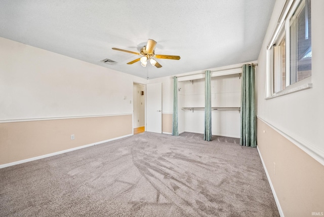 unfurnished bedroom with a ceiling fan, baseboards, carpet, visible vents, and a textured ceiling