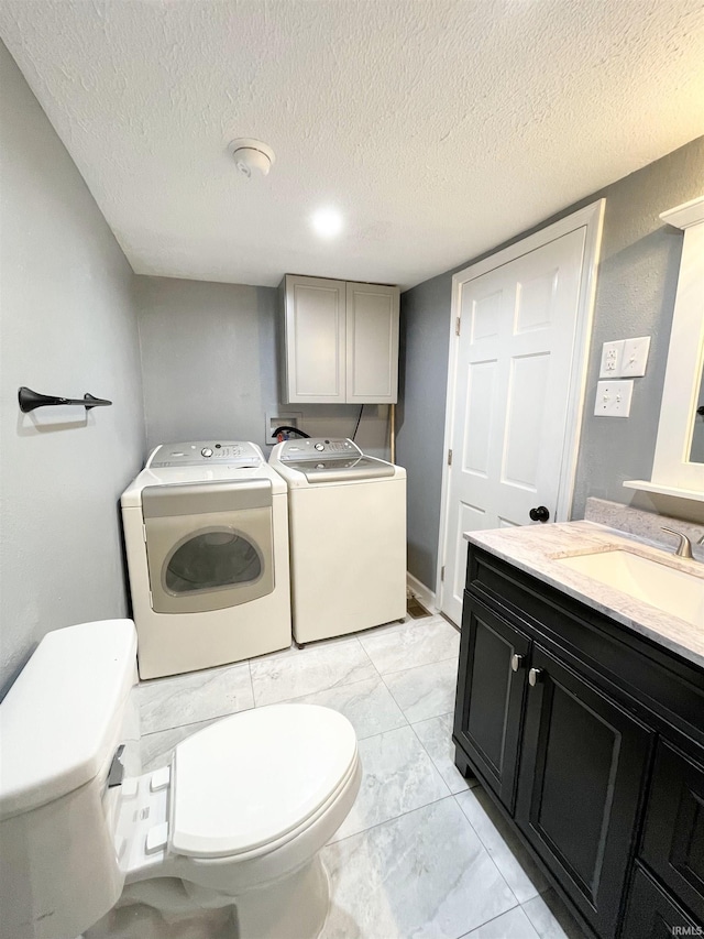laundry room with washer and dryer, a textured ceiling, laundry area, and a sink