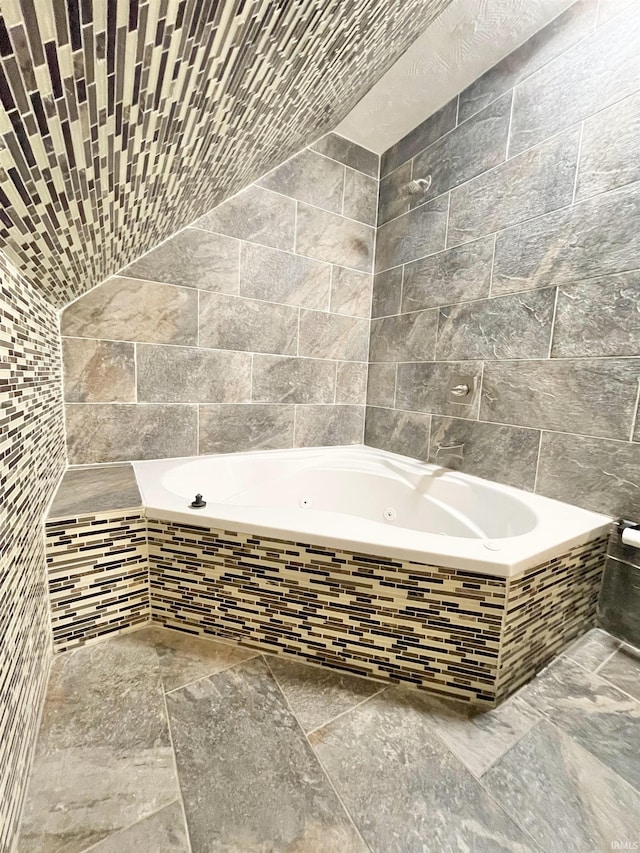 bathroom featuring a jetted tub and tile walls