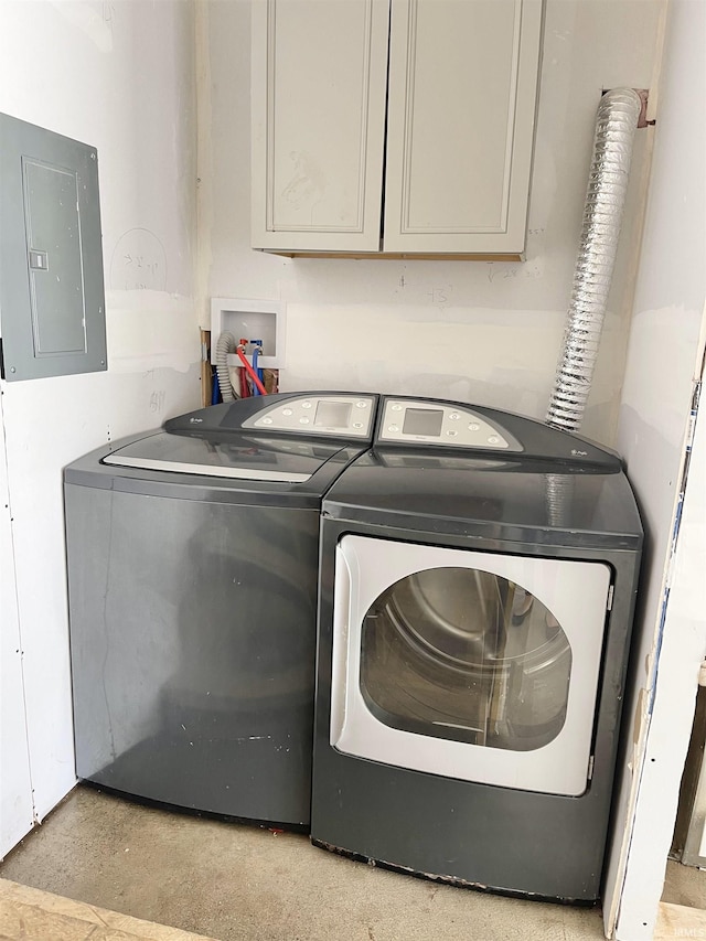 washroom with electric panel, cabinet space, and separate washer and dryer