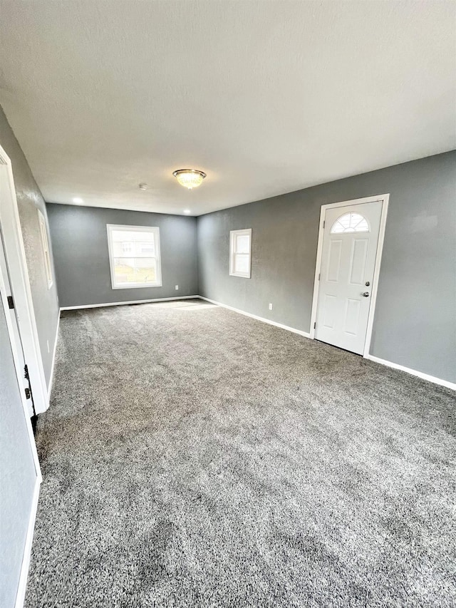 carpeted empty room featuring baseboards and a textured ceiling