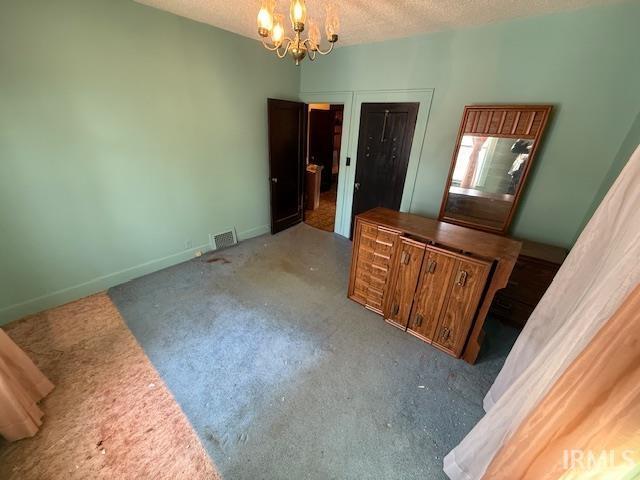 bedroom with visible vents, baseboards, a notable chandelier, and a textured ceiling