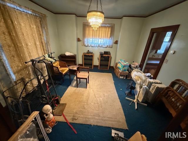 interior space with a notable chandelier, crown molding, and carpet