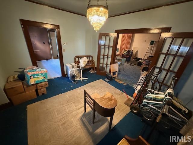 living room featuring carpet flooring, a notable chandelier, french doors, and ornamental molding