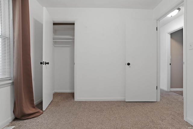 unfurnished bedroom featuring baseboards and carpet