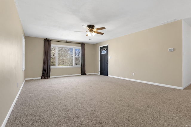 empty room featuring baseboards, light colored carpet, visible vents, and ceiling fan