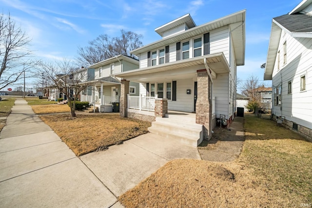 traditional style home featuring brick siding, a residential view, and covered porch