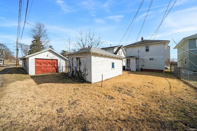 back of house featuring an outdoor structure and fence