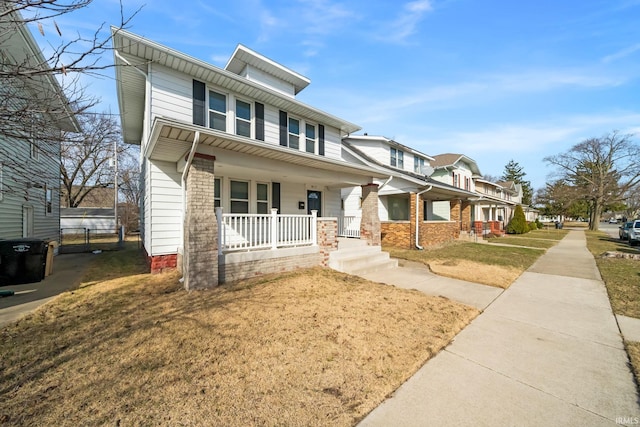 traditional style home featuring a porch and a front lawn