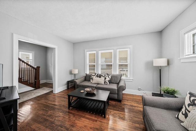 living area featuring stairs, baseboards, and hardwood / wood-style flooring