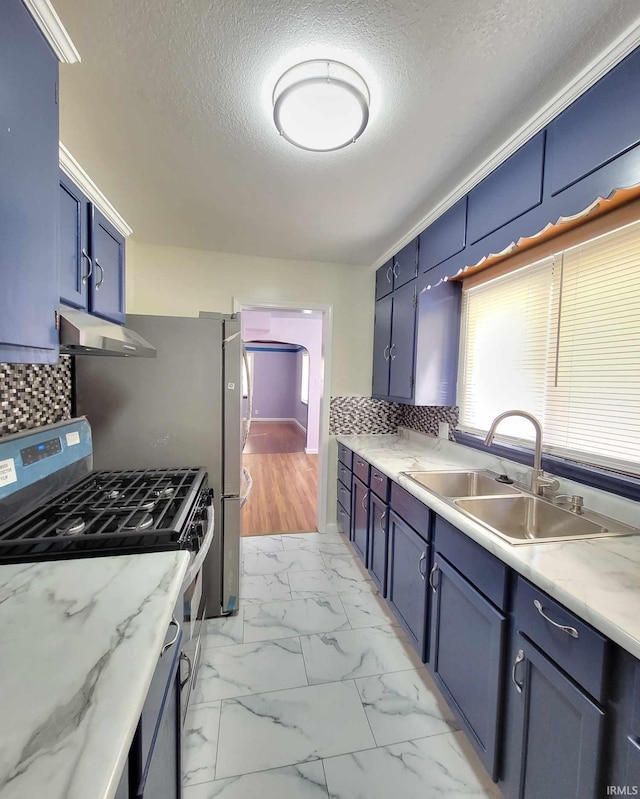 kitchen featuring gas stove, blue cabinetry, a sink, under cabinet range hood, and marble finish floor