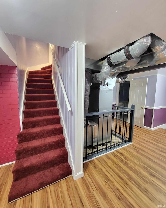 stairway featuring wood finished floors and baseboards