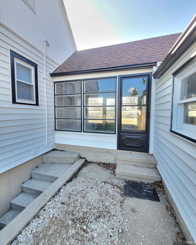 doorway to property featuring a shingled roof