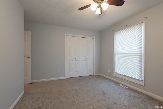 unfurnished bedroom featuring a closet, baseboards, and carpet