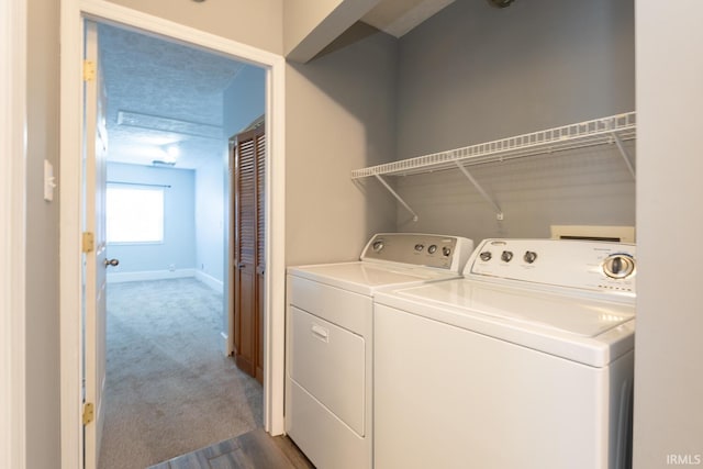 washroom featuring washer and dryer, laundry area, baseboards, and dark colored carpet