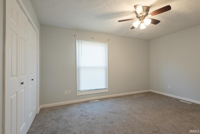 unfurnished bedroom with a closet, baseboards, a textured ceiling, and carpet flooring