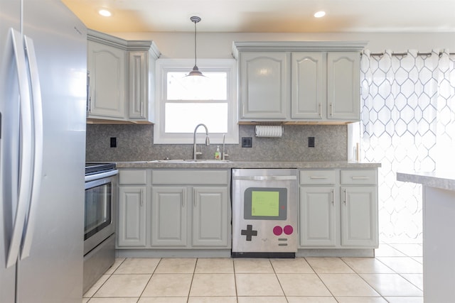 kitchen featuring decorative light fixtures, decorative backsplash, light tile patterned flooring, stainless steel appliances, and a sink