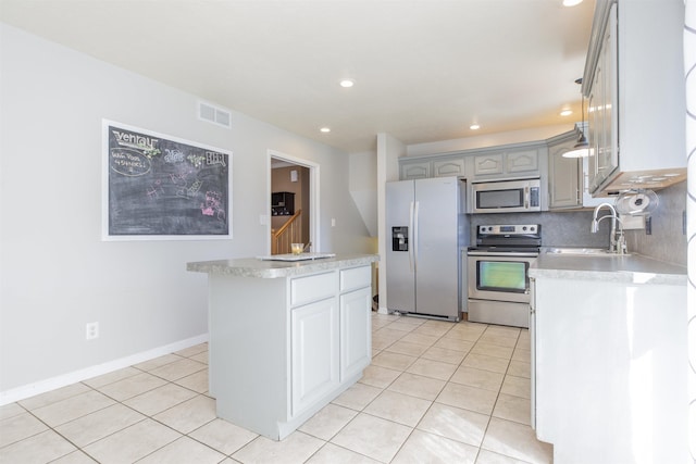 kitchen with visible vents, a sink, light countertops, appliances with stainless steel finishes, and tasteful backsplash