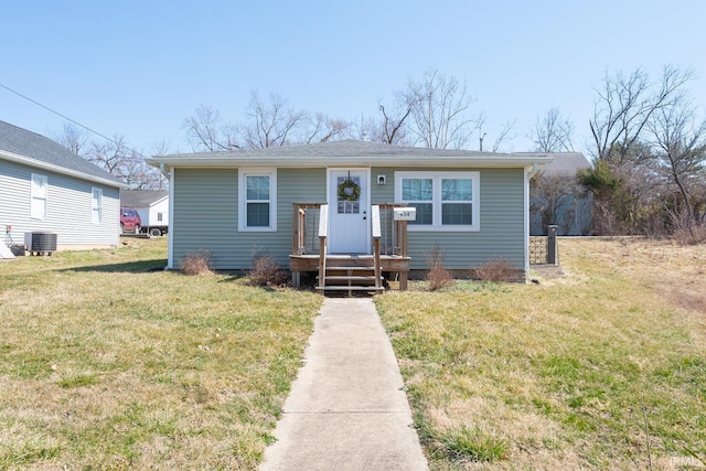 bungalow-style house featuring central air condition unit and a front yard