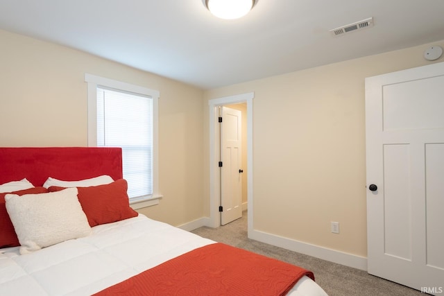 bedroom featuring visible vents, baseboards, and light colored carpet