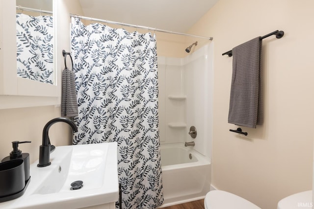 full bath with toilet, shower / bathtub combination with curtain, and a sink