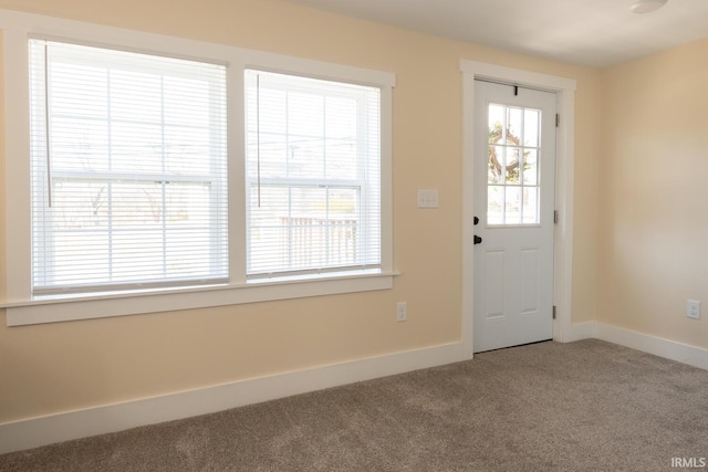 carpeted foyer with baseboards