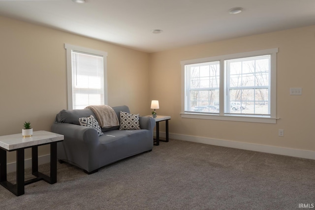 carpeted living area with baseboards