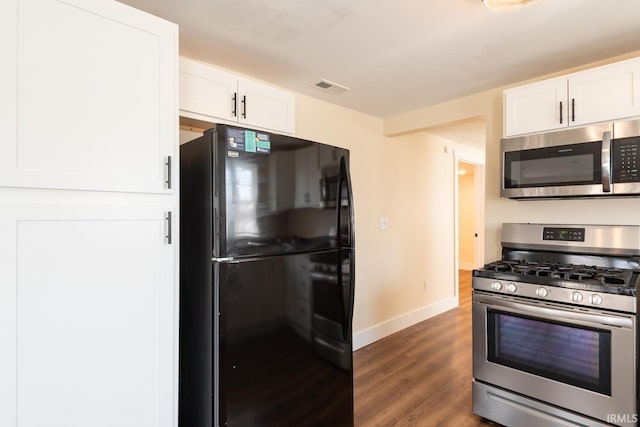 kitchen with white cabinets, wood finished floors, visible vents, and appliances with stainless steel finishes