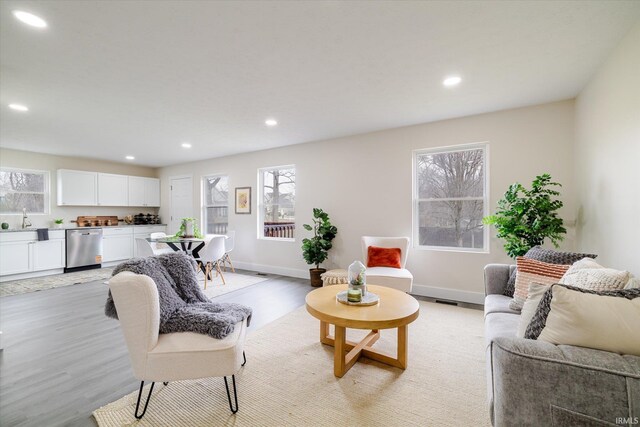 living area with recessed lighting, baseboards, and light wood finished floors