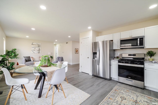 kitchen with white cabinetry, recessed lighting, light wood-style floors, and appliances with stainless steel finishes