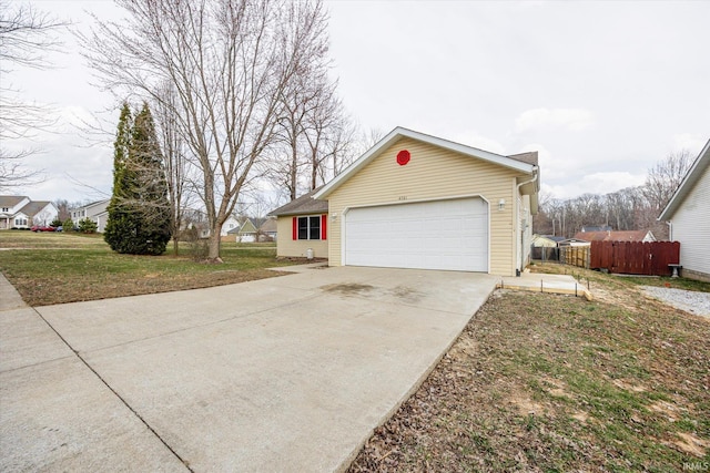 view of home's exterior with an attached garage, driveway, and fence