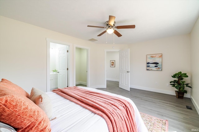 bedroom with visible vents, a ceiling fan, wood finished floors, connected bathroom, and baseboards