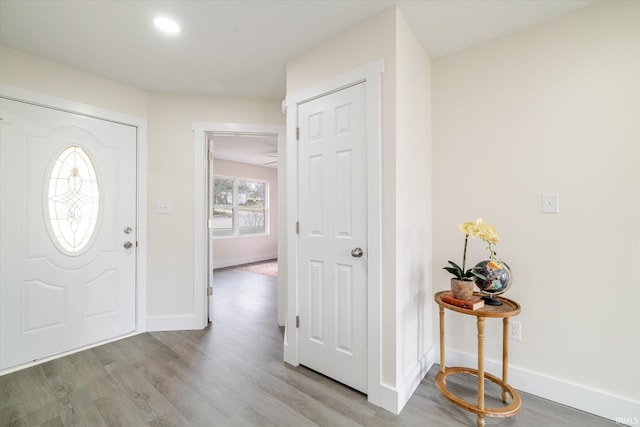 foyer with baseboards and wood finished floors