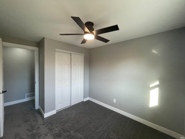 unfurnished bedroom with visible vents, ceiling fan, baseboards, a closet, and dark colored carpet