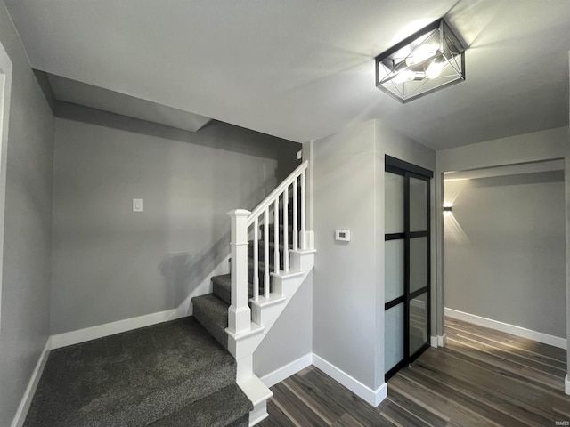 stairway featuring wood finished floors and baseboards