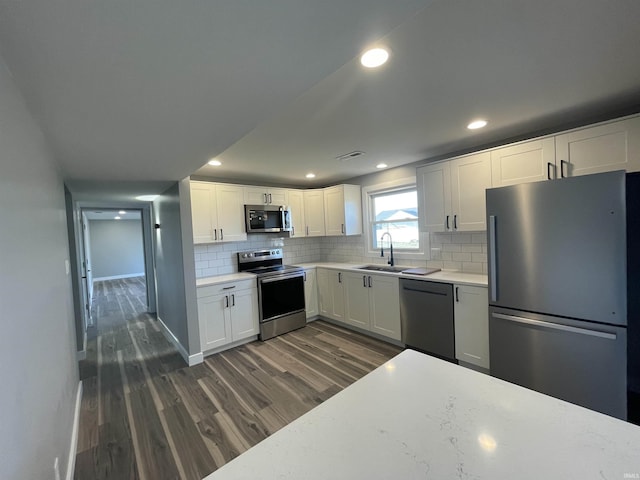 kitchen featuring light countertops, backsplash, dark wood-style flooring, and appliances with stainless steel finishes