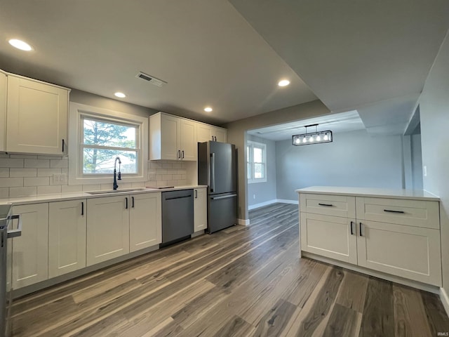 kitchen with visible vents, freestanding refrigerator, a sink, dark wood-type flooring, and dishwasher